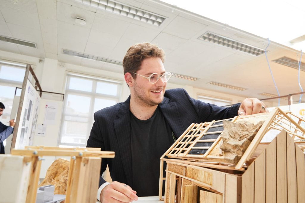 Architecture student with a model of his work at the summer show 2023