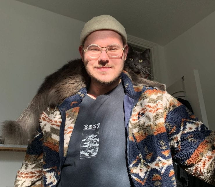 Architecture student Jamie with a cat on his shoulder