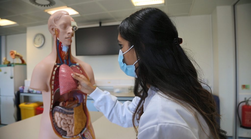 Thivya using a mannequin to study medicine