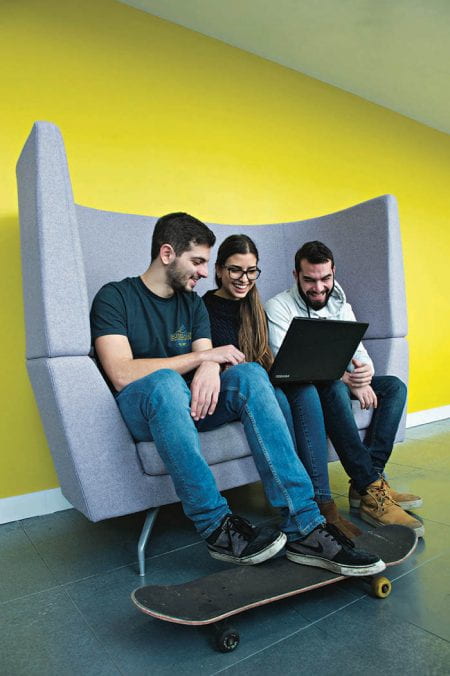 Three students sharing a laptop screen