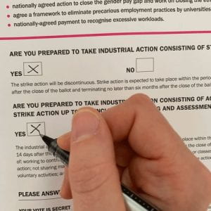 Image of a hand completing a ballot paper