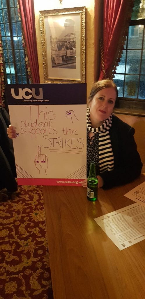 Student holding sign saying "This student supports the strike"