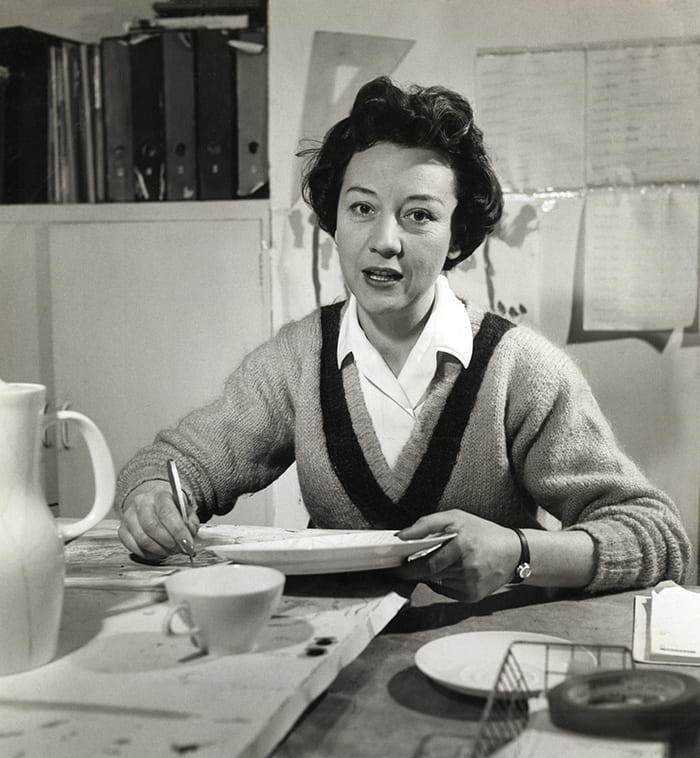 Black and white portrait of Lucienne Day hand painting a plate